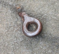 Iron bolt in a boulder at the edge of the river.